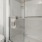 Model bathroom at Hardy Springs senior living apartments in Dallas, GA, featuring a shower with sliding glass doors.